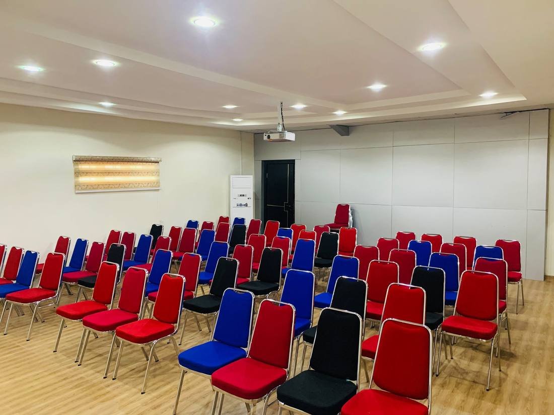 Event hall with rows of chairs and a projector