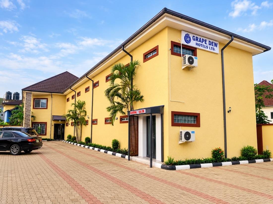 GrapeDew Hotels building with yellow walls and palm trees